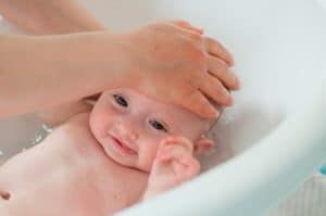 a importância da higiene do bebê. mulher dando banho em bebê.